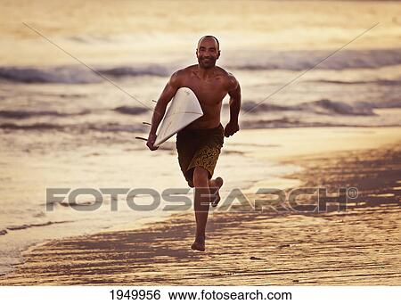 a man runs on the wet beach at sunset with his surfboard; tarifa cadiz andalusia spain View Large Photo Image Stock Photograph - a man runs on the wet beach at sunset with his surfboard; tarifa cadiz andalusia spain. Fotosearch