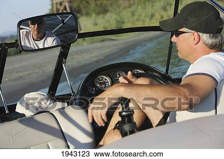 Stock Image - A Man Sitting In A Boat Looking In The Rear View Mirror; Troutdale Oregon United States Of America. Fotosearch