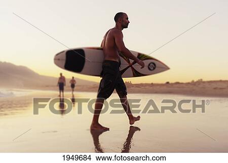 a man walking with his surfboard on valdevaqueros beach; tarifa cadiz andalusia spain View Large Photo Image Picture - a man walking with his surfboard on valdevaqueros beach; tarifa cadiz andalusia spain. Fotosearch