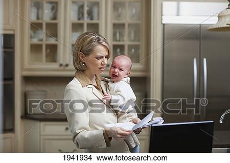 A Mother Holding A Baby And Stressed About Bills And Finances; Jordan Ontario Canada View Large Photo Image Picture - A Mother Holding A Baby And Stressed About Bills And Finances; Jordan Ontario Canada. Fotosearch