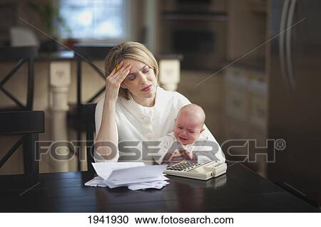 A Mother Holding A Crying Baby While Stressed About Bills And Finances; Jordan Ontario Canada View Large Photo Image Stock Image - A Mother Holding A Crying Baby While Stressed About Bills And Finances; Jordan Ontario Canada. Fotosearch