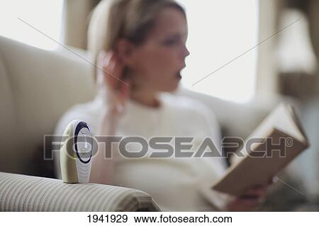 Stock Photo - A Mother Reading A Book With One Ear On The Baby Monitor; Jordan Ontario Canada. Fotosearch