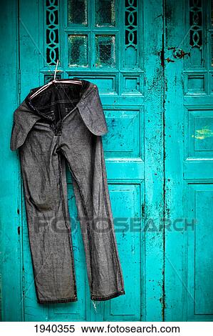 Stock Photography - A Pair Of Freshly Washed Bluejeans Hangs On A Blue Door To Dry In The Midday Sun; Penang Malaysia. Fotosearch