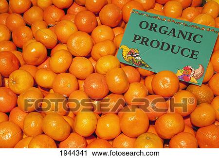 Stock Image - a pile of clementines with a sign labeled organic produce; waterloo quebec canada. Fotosearch