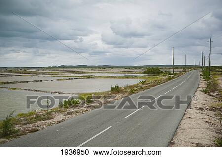 Stock Image - A Road Beside Small Bodies Of Water; South Caicos Turks And Caicos Islands. Fotosearch