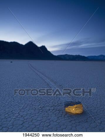 Stock Image - a rock formation glowing on the arid ground in the mojave desert; death valley california united states of america. Fotosearch
