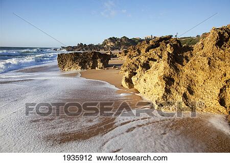 Stock Image - A Rugged Rock Formation Along A Beach Near Chiclana De La Frontera; Andalusia, Spain. Fotosearch