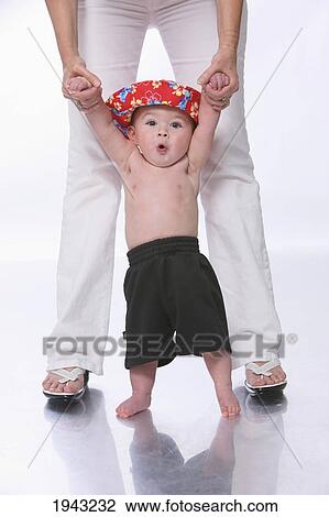 Stock Image - A Shirtless Baby Boy Standing Between Mother's Legs; Troutdale Oregon United States Of America. Fotosearch