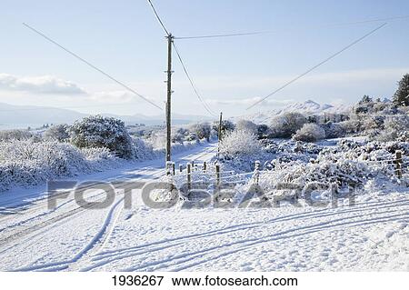 Stock Photo - A Snow Covered Road In Winter; Tahilla County Kerry Ireland. Fotosearch