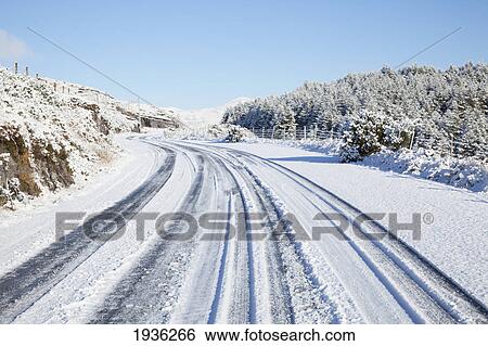Stock Photograph - A Snow Covered Road In Winter; Tahilla County Kerry Ireland. Fotosearch
