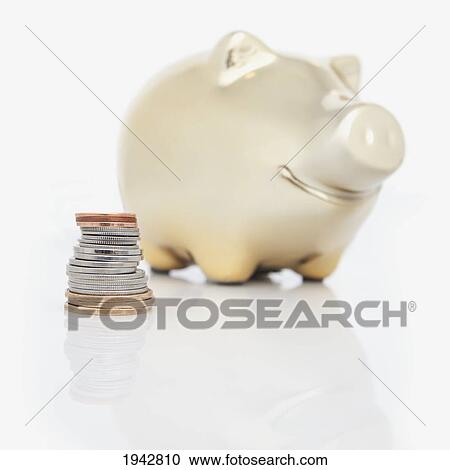 Stock Image - A Stack Of Coins Beside A Piggy Bank. Fotosearch