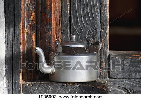 Stock Image - A Stainless Steel Kettle Sitting On A Wooden Ledge; Thimphu, Thimphu District, Bhutan. Fotosearch