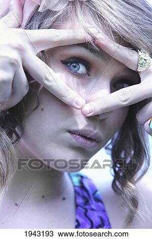 A Teenage Girl Holding Fingers Around Her Eye; Troutdale Oregon United States Of America View Large Photo Image Stock Image - A Teenage Girl Holding Fingers Around Her Eye; Troutdale Oregon United States Of America. Fotosearch