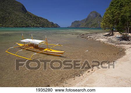 A Tradional Wooden Bangka Boat Sits In The Picturesque And Scenic Bay; El Nido, Bacuit Archipelago, Palawan, Philippines View Large Photo Image Stock Image - A Tradional Wooden Bangka Boat Sits In The Picturesque And Scenic Bay; El Nido, Bacuit Archipelago, Palawan, Philippines. Fotosearch