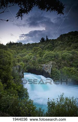 Stock Photograph - A Waterfall Surrounded By A Forested Area; New Zealand. Fotosearch