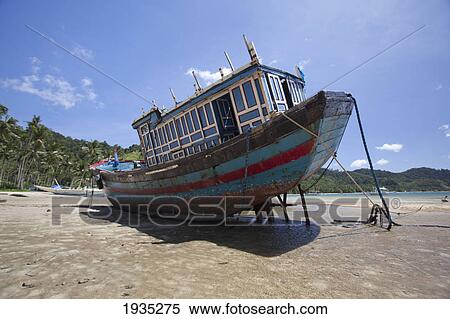 Stock Photography - A Wooden Boat Sits In The Mudflats At Low Tide In The Bay Of Corong Corong; El Nido, Bacuit Archipelago, Palawan, Philippines. Fotosearch