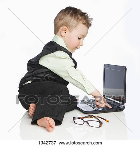 A Young Boy Dressed In A Suit Using A Laptop Computer; Edmonton Alberta Canada View Large Photo Image Stock Photo - A Young Boy Dressed In A Suit Using A Laptop Computer; Edmonton Alberta Canada. Fotosearch