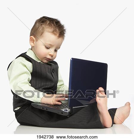 A Young Boy Dressed In A Suit Using A Laptop Computer; Edmonton Alberta Canada View Large Photo Image Stock Photo - A Young Boy Dressed In A Suit Using A Laptop Computer; Edmonton Alberta Canada. Fotosearch
