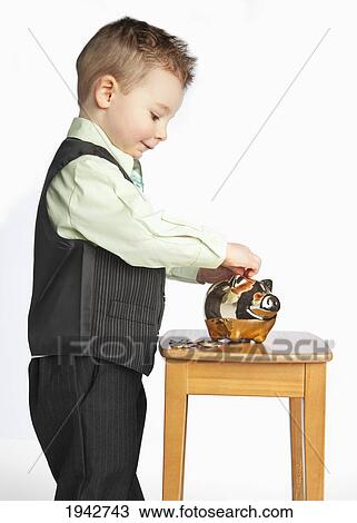 A Young Boy Wearing A Suit Putting Money In His Piggy Bank; Edmonton Alberta Canada View Large Photo Image Stock Image - A Young Boy Wearing A Suit Putting Money In His Piggy Bank; Edmonton Alberta Canada. Fotosearch