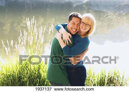 A Young Couple Embrace In Front Of Sylvan Lake; South Dakota United States Of America View Large Photo Image Stock Photo - A Young Couple Embrace In Front Of Sylvan Lake; South Dakota United States Of America. Fotosearch