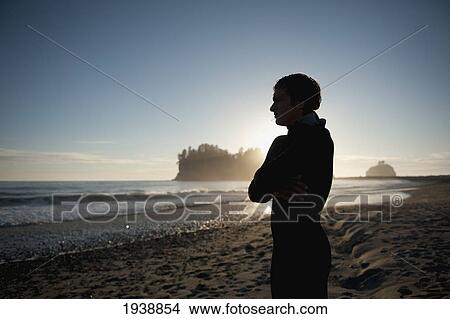 Picture - A Young Man Stands On The Beach At Sunset; La Push Washington United States Of America. Fotosearch
