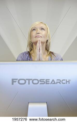 Stock Photograph - a young woman finds inspiration behind her computer screen; south shields tyne and wear england. Fotosearch