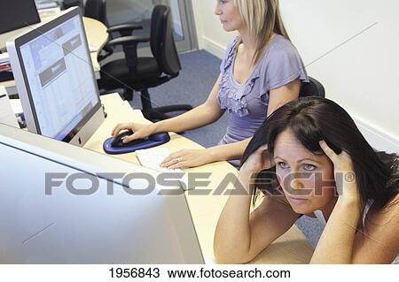 Stock Image - a young woman is confused as she looks at her computer screen; south shields tyne and wear england. Fotosearch