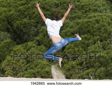 A Young Woman Leaps Over The Punta Paloma Sand Dunes; Tarifa Cadiz Andalusia Spain View Large Photo Image Stock Photography - A Young Woman Leaps Over The Punta Paloma Sand Dunes; Tarifa Cadiz Andalusia Spain. Fotosearch