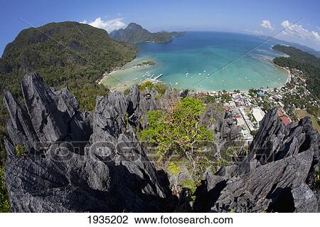 Stock Image - An Aerial Fisheye View From The Top Of Sharp Limestone Spires Overlooking The Village Of El Nido; El Nido, Bacuit Archipelago, Palawan, Philippines. Fotosearch