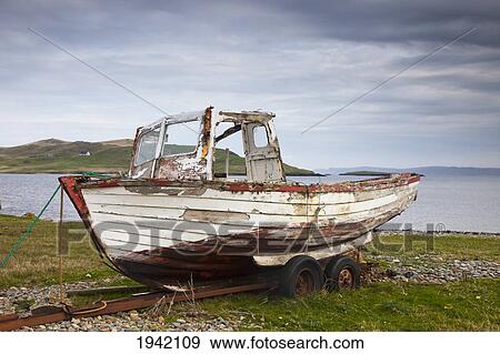 Stock Photo - An Old Abandoned Boat On The Shore; Shetland Scotland. Fotosearch