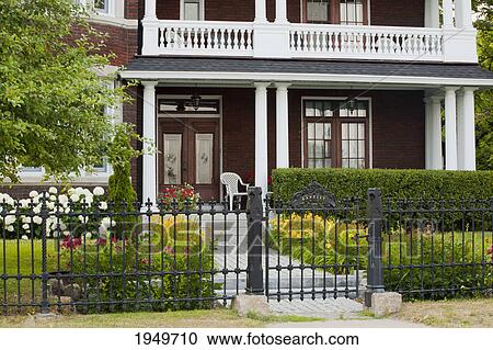 Stock Image - an old residence with a balcony and a wrought iron fence; trois rivieres quebec canada. Fotosearch
