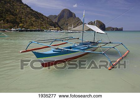 Bangka Boats Sit In The Picturesque And Scenic Bay; El Nido, Bacuit Archipelago, Palawan, Philippines View Large Photo Image Stock Photo - Bangka Boats Sit In The Picturesque And Scenic Bay; El Nido, Bacuit Archipelago, Palawan, Philippines. Fotosearch