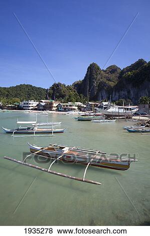 Stock Photo - Bangka Boats Sit In The Picturesque And Scenic Bay; El Nido, Bacuit Archipelago, Palawan, Philippines. Fotosearch