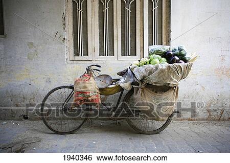 Bicycle Carrying Vegetables Leaning Against A Wall In Nizamuddin; Delhi India View Large Photo Image Stock Photograph - Bicycle Carrying Vegetables Leaning Against A Wall In Nizamuddin; Delhi India. Fotosearch
