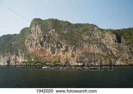 Stock Image - Boat Passing Ocean Coast; Phuket Thailand. Fotosearch