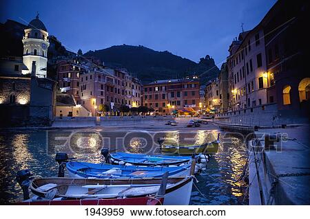 Boats Moored By Buildings Along The Waterfront At Night; Vernazza Liguria Italy View Large Photo Image Stock Photo - Boats Moored By Buildings Along The Waterfront At Night; Vernazza Liguria Italy. Fotosearch