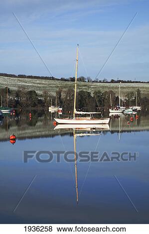 Stock Photo - Boats Moored In The Water Along The Shoreline In Winter Near Carrigaline; County Cork Ireland. Fotosearch