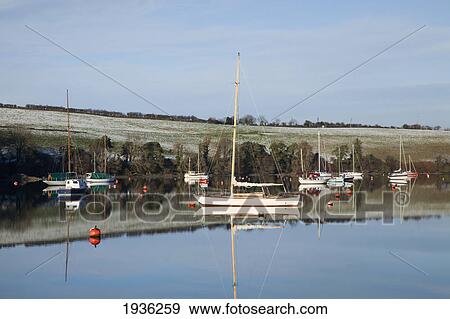 Boats Moored In The Water Along The Shoreline In Winter Near Carrigaline; County Cork Ireland View Large Photo Image Stock Photo - Boats Moored In The Water Along The Shoreline In Winter Near Carrigaline; County Cork Ireland. Fotosearch