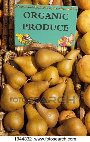 Stock Image - bosch pears with a sign labeled organic produce; waterloo quebec canada. Fotosearch