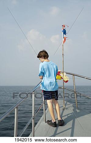 Stock Photography - Boy On Boat With Flag Of Thailand; Phi Phi Island Thailand. Fotosearch