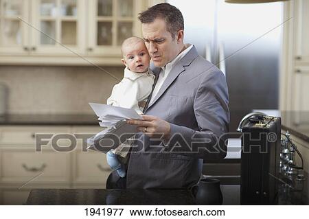 Businessman Father With Baby Stressing Over Household Bills; Jordan Ontario Canada View Large Photo Image Stock Photo - Businessman Father With Baby Stressing Over Household Bills; Jordan Ontario Canada. Fotosearch