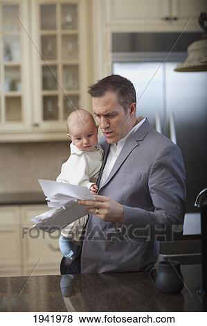 Businessman Father With Baby Stressing Over Household Bills; Jordan Ontario Canada View Large Photo Image Stock Photo - Businessman Father With Baby Stressing Over Household Bills; Jordan Ontario Canada. Fotosearch