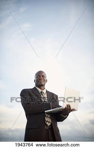 Businessman Using A Laptop Computer; South Caicos Turks And Caicos Islands View Large Photo Image Picture - Businessman Using A Laptop Computer; South Caicos Turks And Caicos Islands. Fotosearch