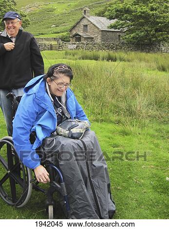 Stock Photography - Elderly Woman In Wheelchair Laughing; Martindale England. Fotosearch
