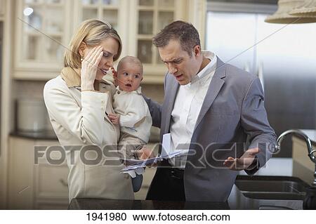 Stock Image - Husband And Wife With Baby Stressing Over Household Bills; Jordan Ontario Canada. Fotosearch