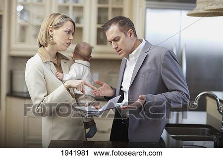 Stock Image - Husband And Wife With Baby Stressing Over Household Bills; Jordan Ontario Canada. Fotosearch