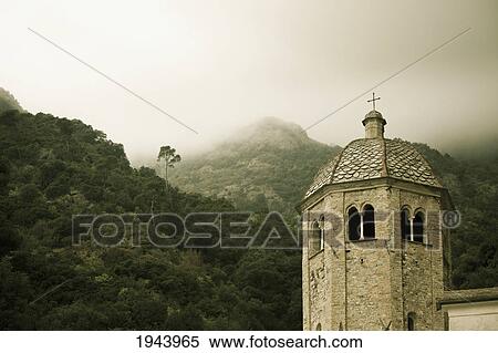 Stock Photography - Low Lying Cloud In The Hills And A Cross Atop A Building's Tower; San Frutuozzo Liguria Italy. Fotosearch