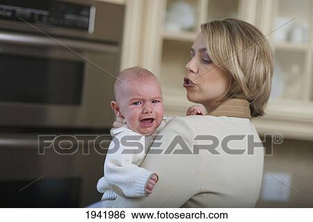 Mother Comforting Crying Baby; Jordan Ontario Canada View Large Photo Image Stock Photograph - Mother Comforting Crying Baby; Jordan Ontario Canada. Fotosearch