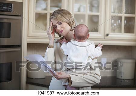 Mother With Baby Stressing Over Household Bills; Jordan Ontario Canada View Large Photo Image Stock Photo - Mother With Baby Stressing Over Household Bills; Jordan Ontario Canada. Fotosearch