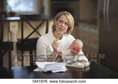 Stock Photograph - Mother With Baby Stressing Over Household Finances; Jordan Ontario Canada. Fotosearch